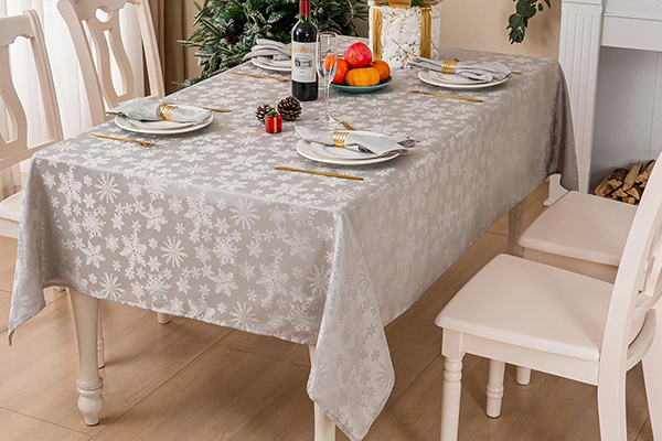 What design elements and patterns are commonly used in Christmas tablecloths to reflect the holiday spirit?